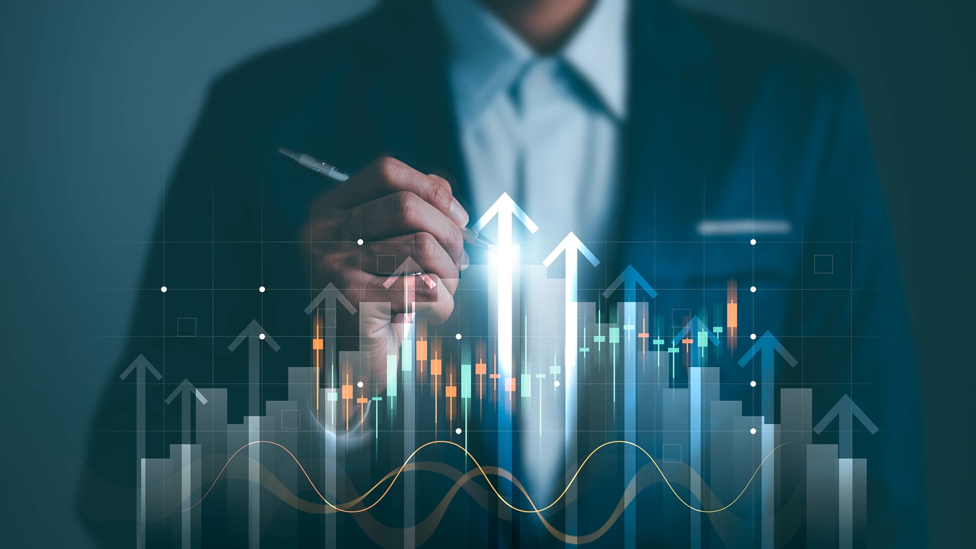 A person in a suit holds a pen, pointing at a digital graph with ascending arrows and candlestick charts, symbolizing financial growth and success.